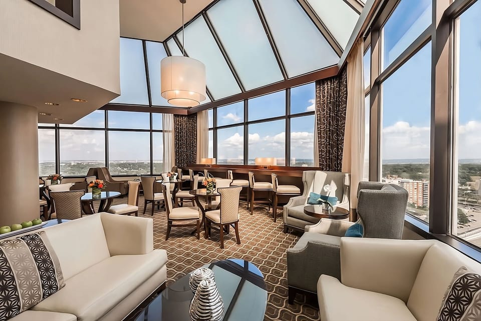 Relax in a sunlit lounge framed by panoramic city vistas.
