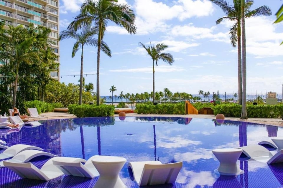 Lounge in-water as palm shadows dance across the surface.