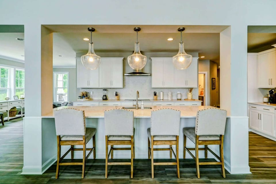 Large fully stocked kitchen with huge island, new stainless steel appliances, and large pantry.