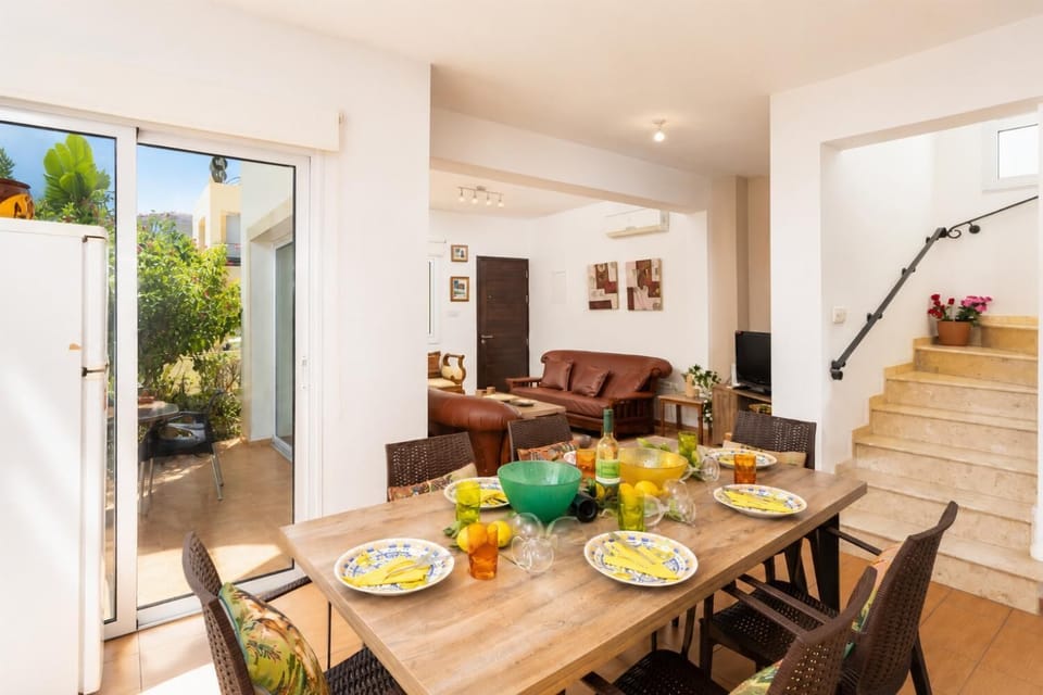 Open-plan living room with sofas, dining area, kitchen, A/C, WiFi internet, and satellite TV