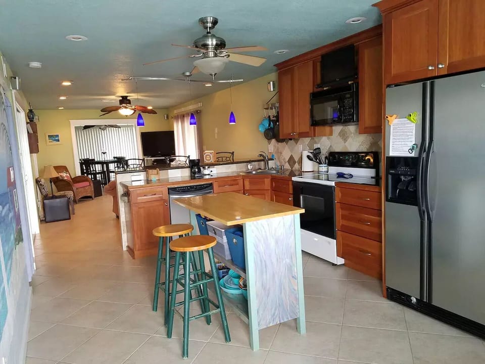 Open kitchen w island & raised bar separating Living Room