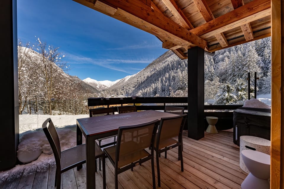 Large balcony off living area with hot tub and dining table