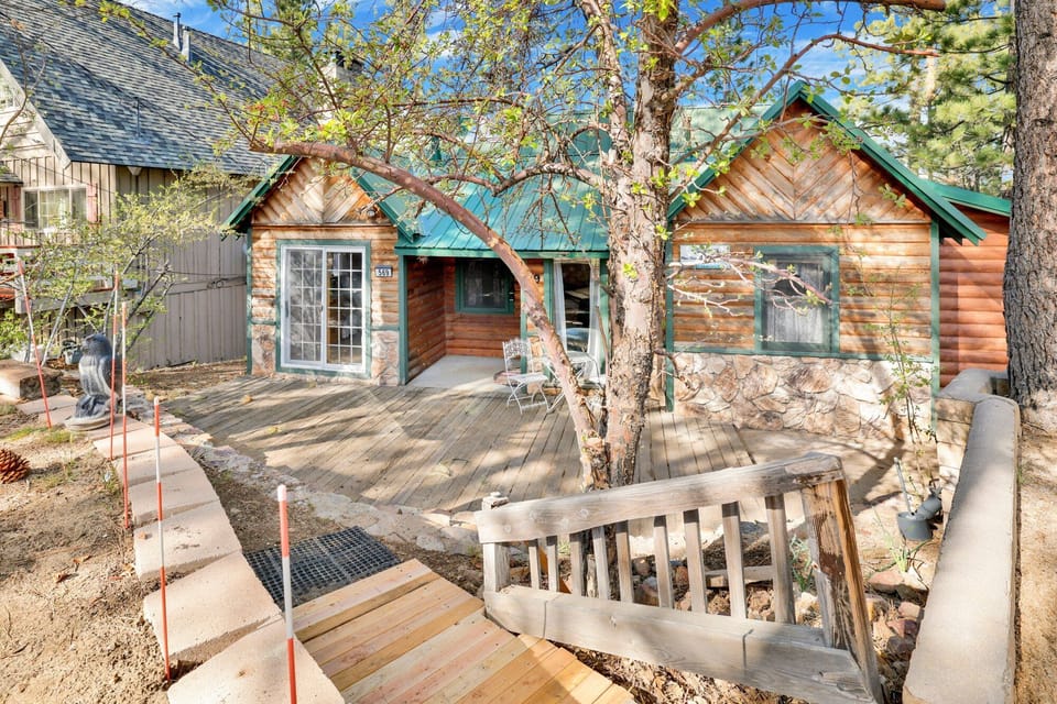 Welcoming cabin entry surrounded by towering pine trees, offering fresh mountain air and a peaceful forest setting—the perfect first impression for your Big Bear Lake getaway.