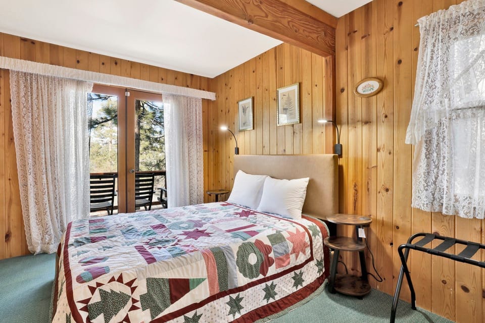 Peaceful cabin bedroom with plush bedding, and beautiful views—ideal for restful nights, cozy mornings, and a relaxing mountain escape.