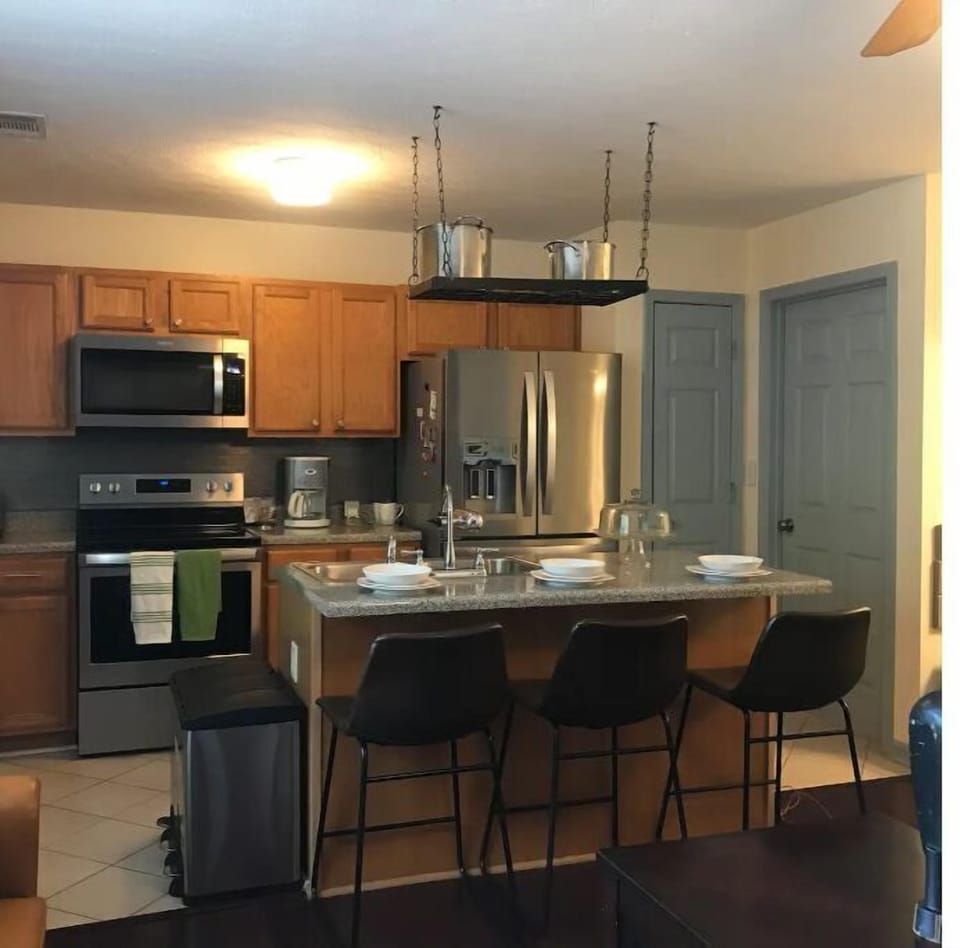 Kitchen, kitchen island, stainless steel appliances and overhead pot rack