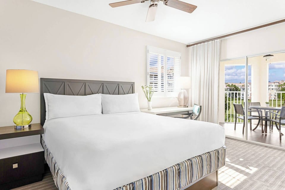 Primary Bedroom features a king bed, ensuite bath, and door to a private furnished patio.