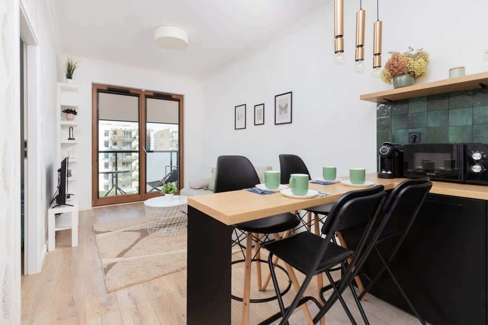 A wide shot of the living and dining area, showing the sofa, coffee table, and kitchen layout.
