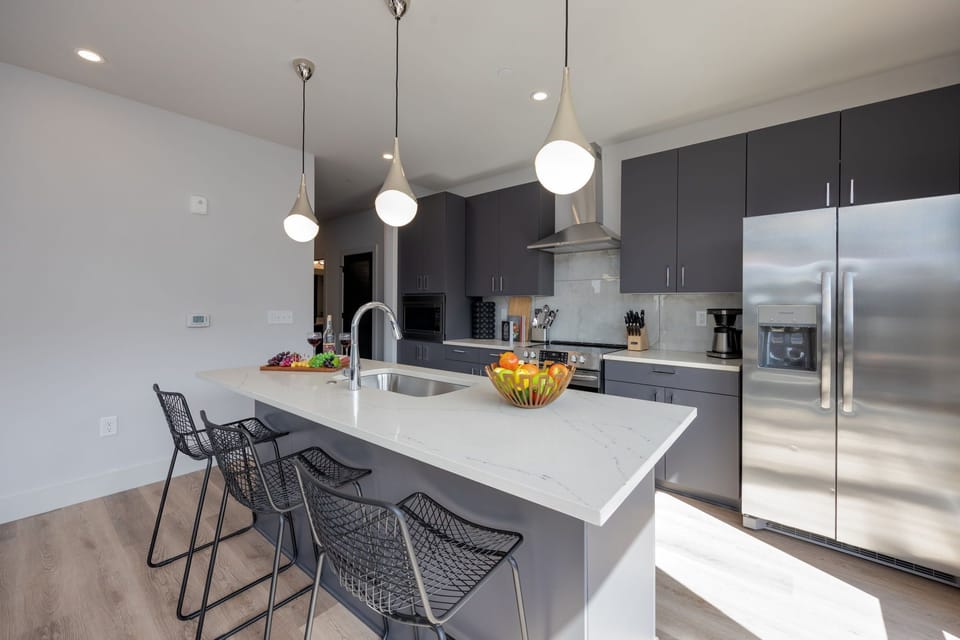 Fully equipped kitchen stocked with basic cooking essentials. Includes stainless steel appliances and kitchen island seating.