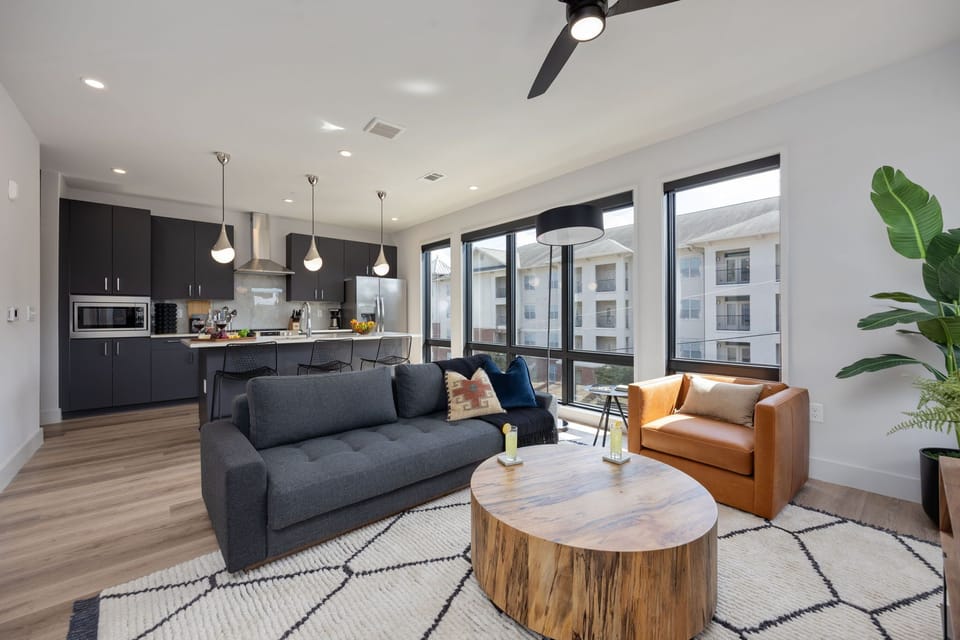 Bright open concept living area with floor to ceiling windows providing panoramic views of Midtown! Features designer furniture, smart TV, and access to private balcony.