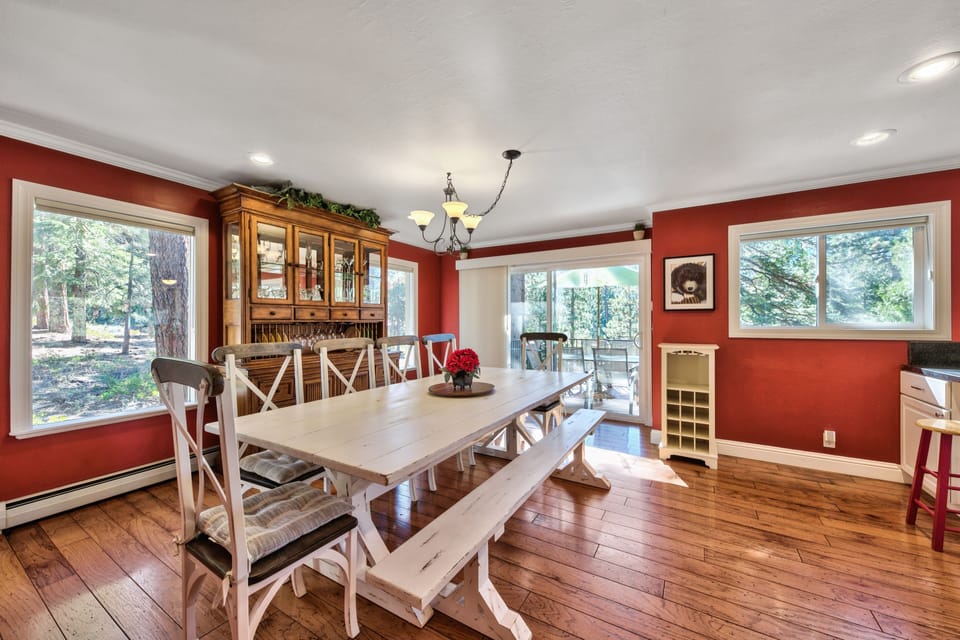 Gather around your farmhouse-style dining table in this warm, inviting space with rich red walls and gleaming hardwood floors.