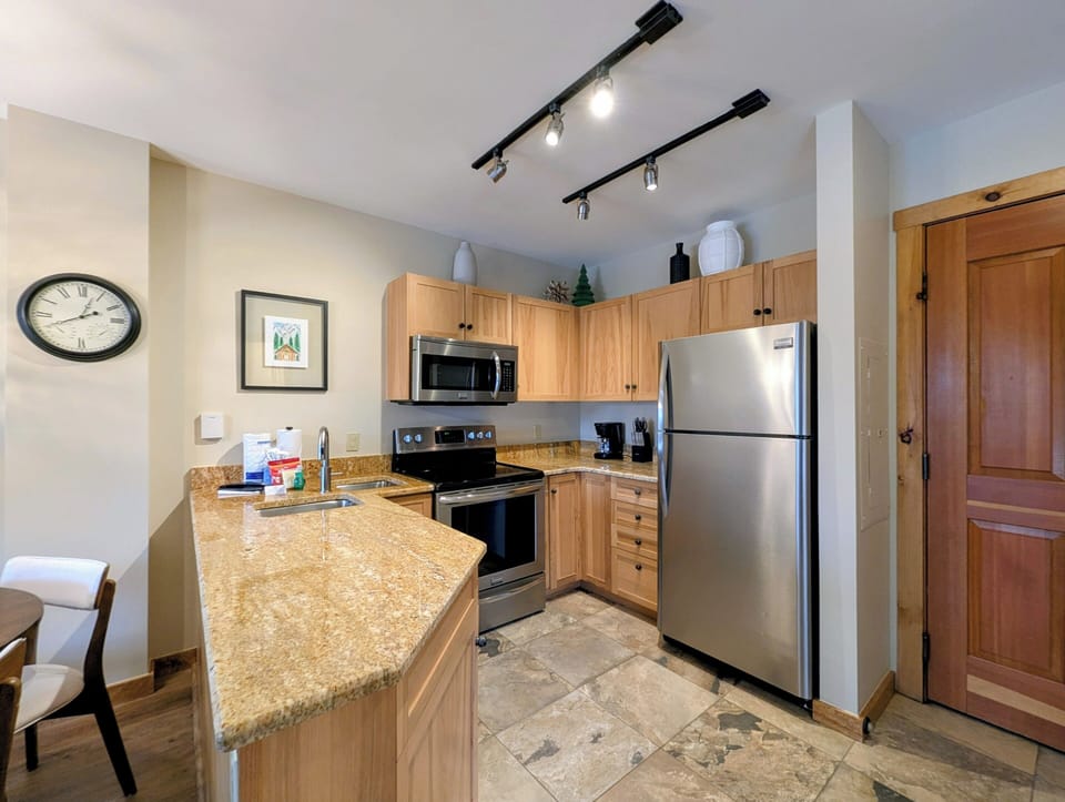Your fully equipped kitchen features granite counters, stainless appliances, and warm wood cabinetry—perfect for creating memorable meals during your stay.