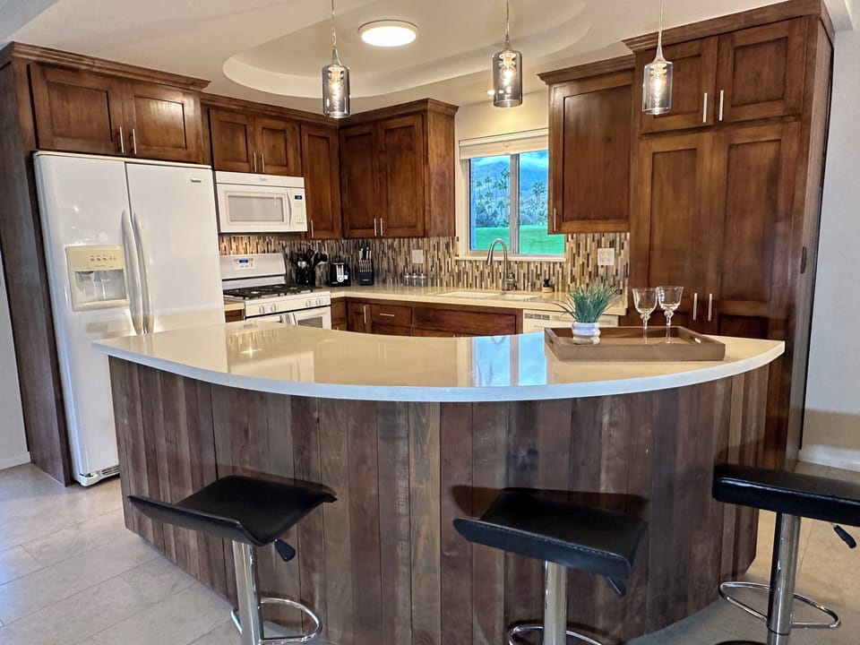 Fully equipped kitchen with walnut cabinets and quartz countertops.