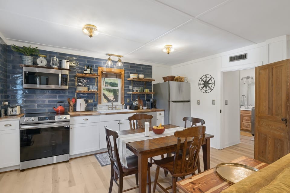 Kitchen looking into second bathroom with full laundry