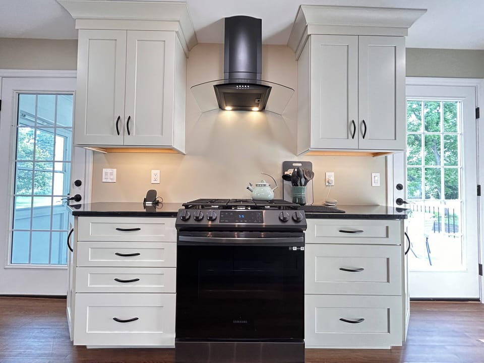 Gas range in a very well-stocked kitchen with lots of natural light.