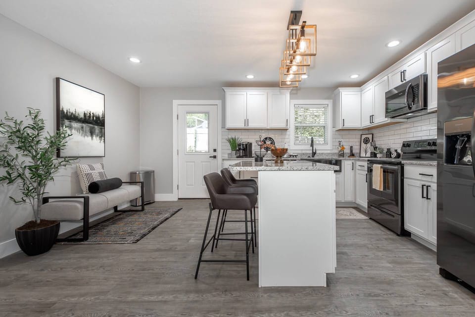 View of the fully equipped kitchen with granite counters, stainless steel appliances and island with seating for 2