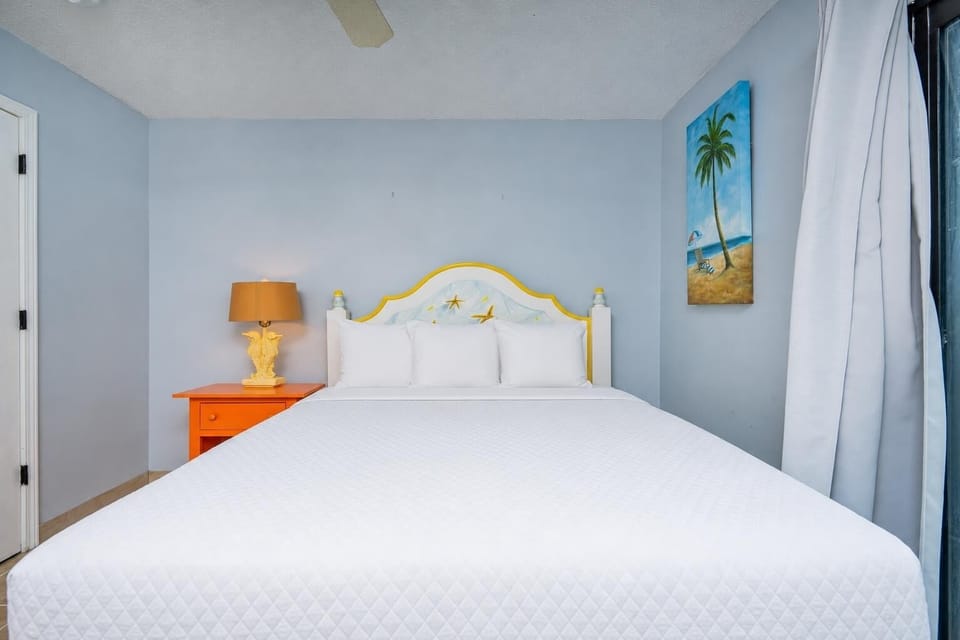 This bedroom features a bright yellow and white headboard, colorful decor, and a cozy atmosphere perfect for relaxation