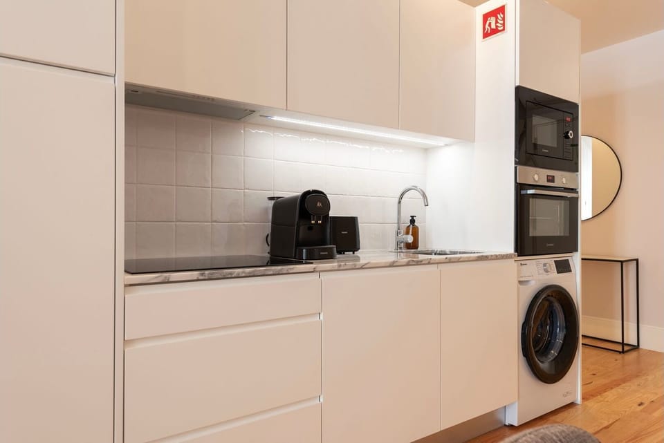 The kitchenette features sleek, high-end appliances and ample counter space, stocked with all the essentials, from cookware to utensils.