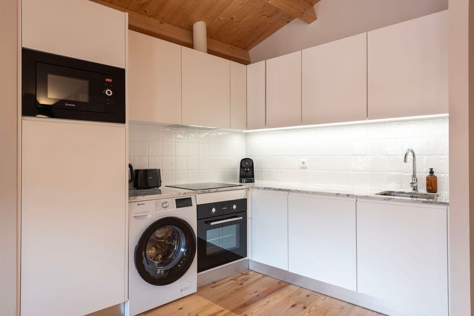 The kitchenette features sleek, high-end appliances and ample counter space, stocked with all the essentials, from cookware to utensils.
