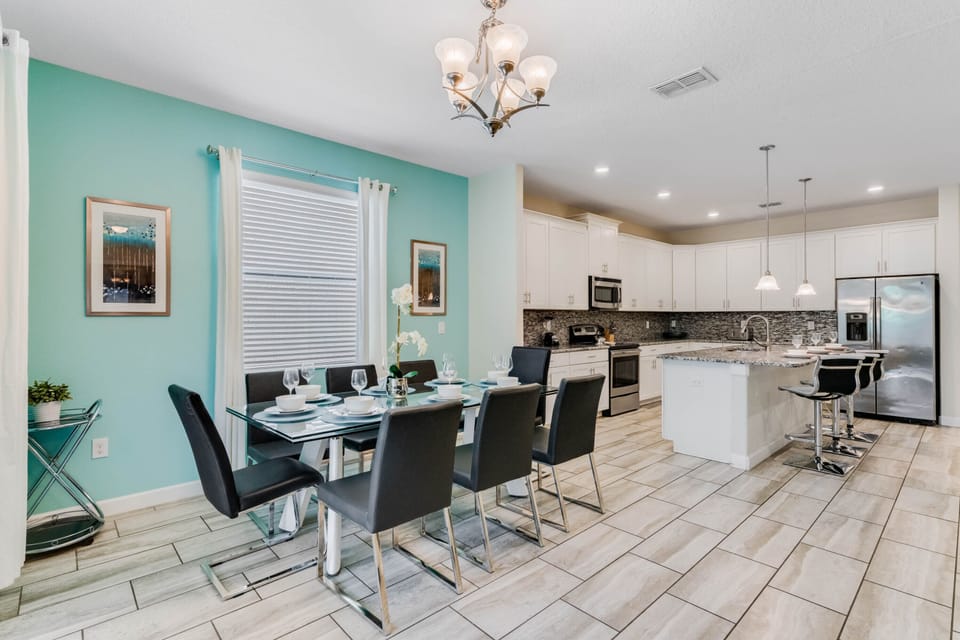 - Spacious dining area with seating for eight guests  
- Modern glass table and chic black chairs in open plan  
- Perfect space for family dinners near Orlando parks