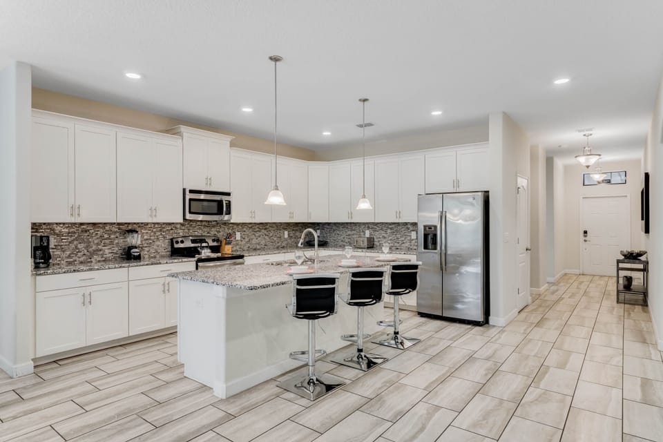 - Gourmet kitchen with granite island and pendant lights  
- Stainless steel fridge and plenty of storage space  
- Ideal for cooking meals before Orlando adventures