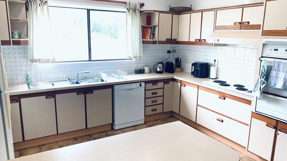 Kitchen with dishwasher refrigerator oven and bench top facilities.
