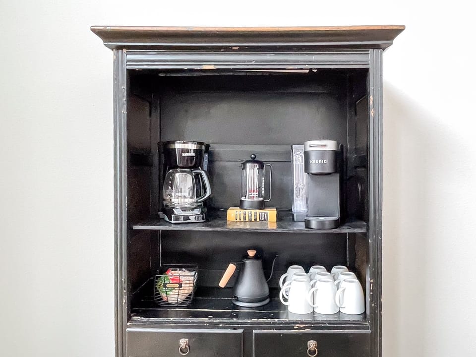 Coffee bar stocked with a coffee pot, Keurig, french press, and electric kettle
