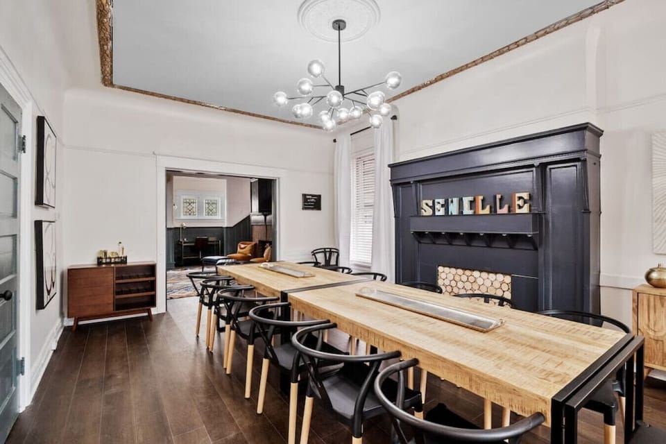 The grand entrance hall, featuring a fireplace and adjacent to the primary bedroom, leads to a dining room equipped with a second grand fireplace, comfortably seating 12 guests. The adjoining living room provides access to the backyard, all on the main fl