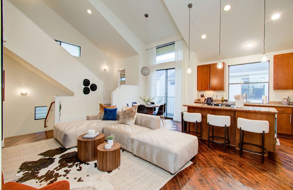 Living room and kitchen island that showcases cozy and airy space