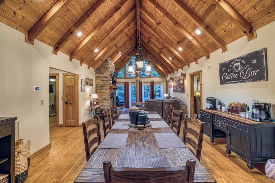 Vaulted ceilings, natural light, hardwood floors, a cozy sectional, gas fireplace, Smart TV, and dining area await. Step outside through the back door to an elevated screened sitting area, perfect for relaxing and soaking in the peaceful vibes.