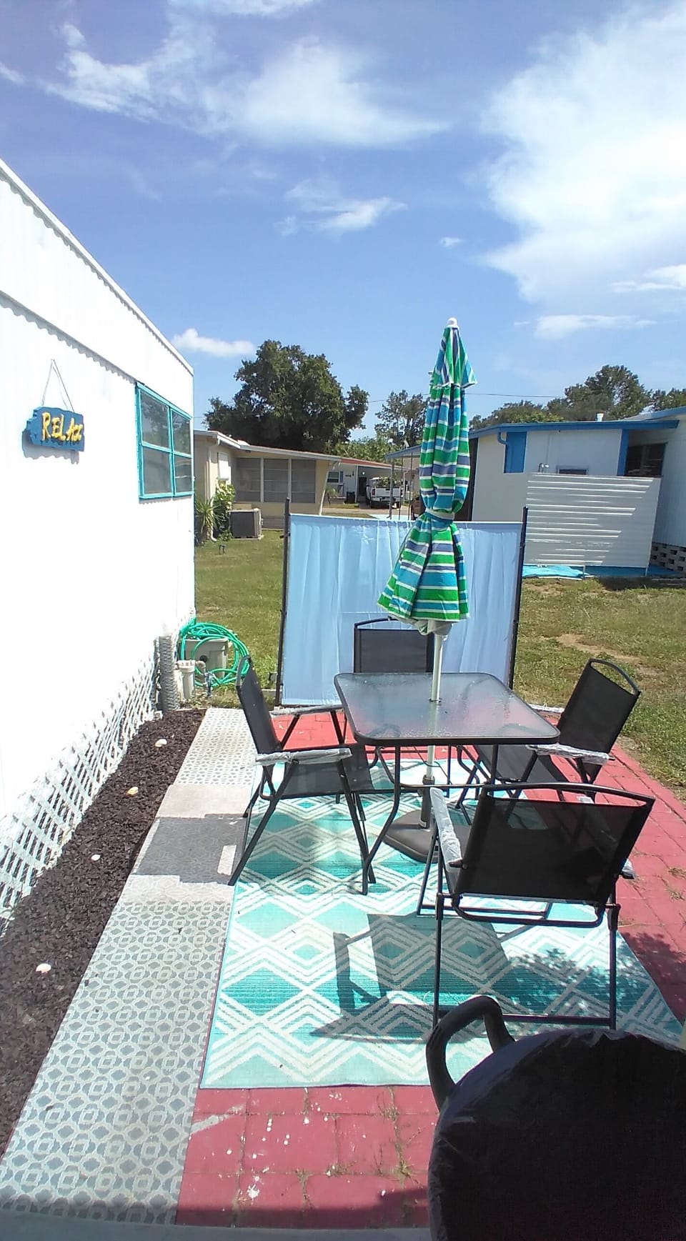 Outdoor one of two patios , umbrella and chairs to relax with some privacy shade
