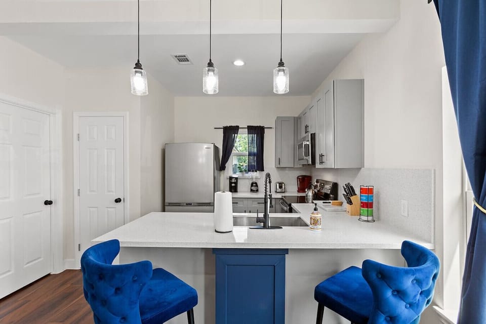 Modern kitchen with full-size appliances, quartz counters, and island seating—perfect for quick breakfasts or evening meals.