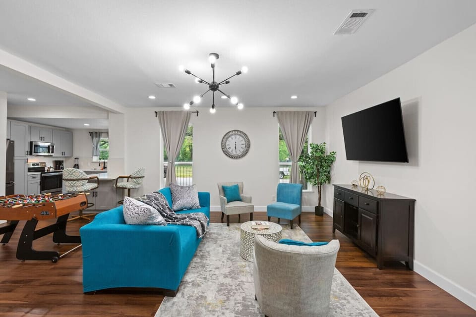 Spacious living room with smart TV, comfortable seating, and easy flow into the dining area — ideal for movie nights or remote work.