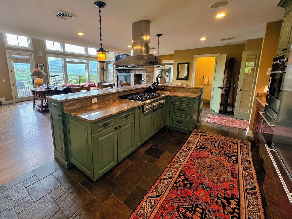 The chef's kitchen boasts granite countertops, a 6-burner stove, double ovens, and a built-in microwave—perfect for preparing gourmet meals.