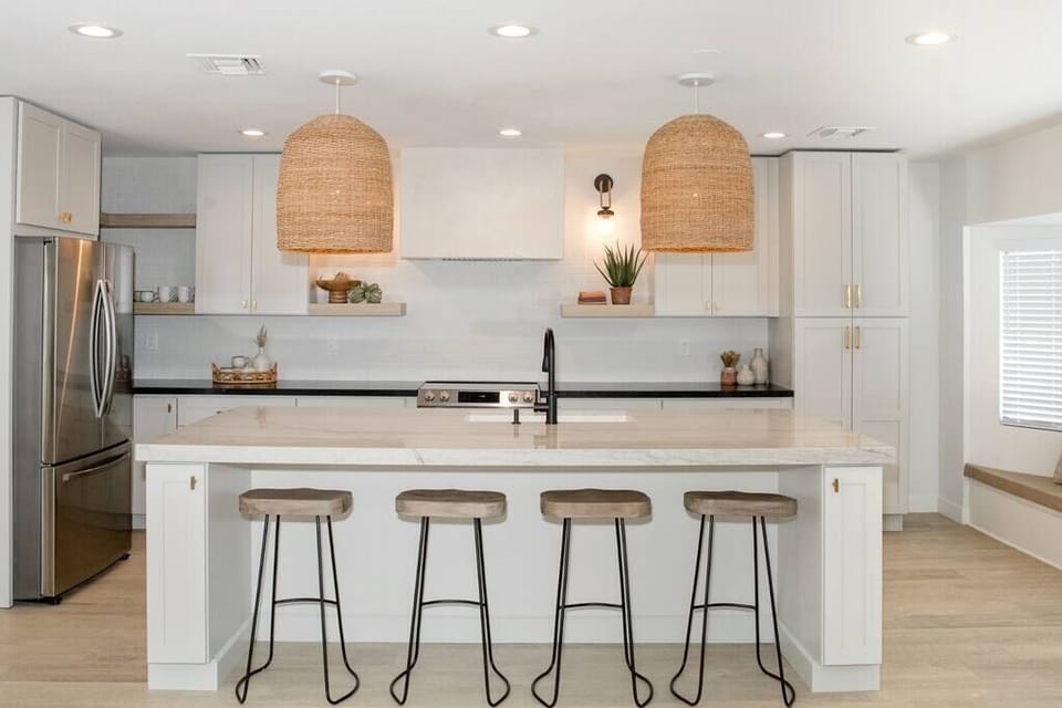 Modern kitchen with a large marble island and woven pendant lighting