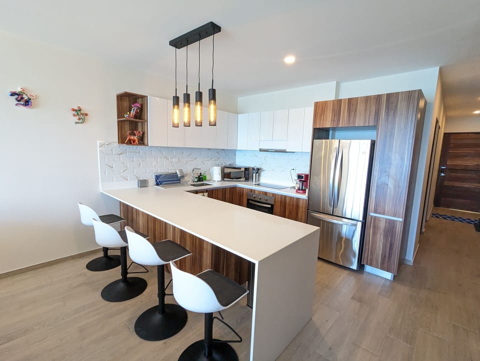 The kitchen bar area offers a comfortable sitting area with 4 bar tools.