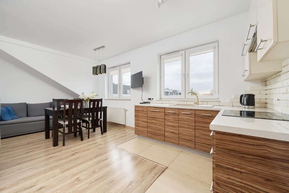 A modern kitchen and dining area featuring wooden cabinets, sleek appliances, and a spacious layout with natural light.

