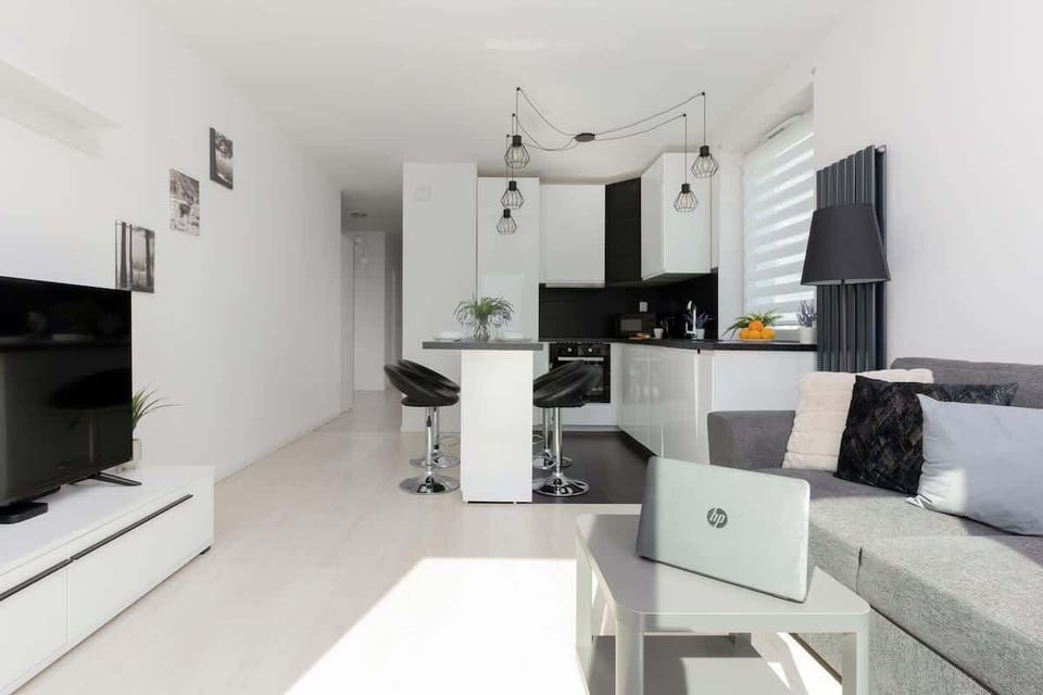 An angle showing the open-plan kitchen, dining area, and living room, showcasing the flow of space and contemporary design.
