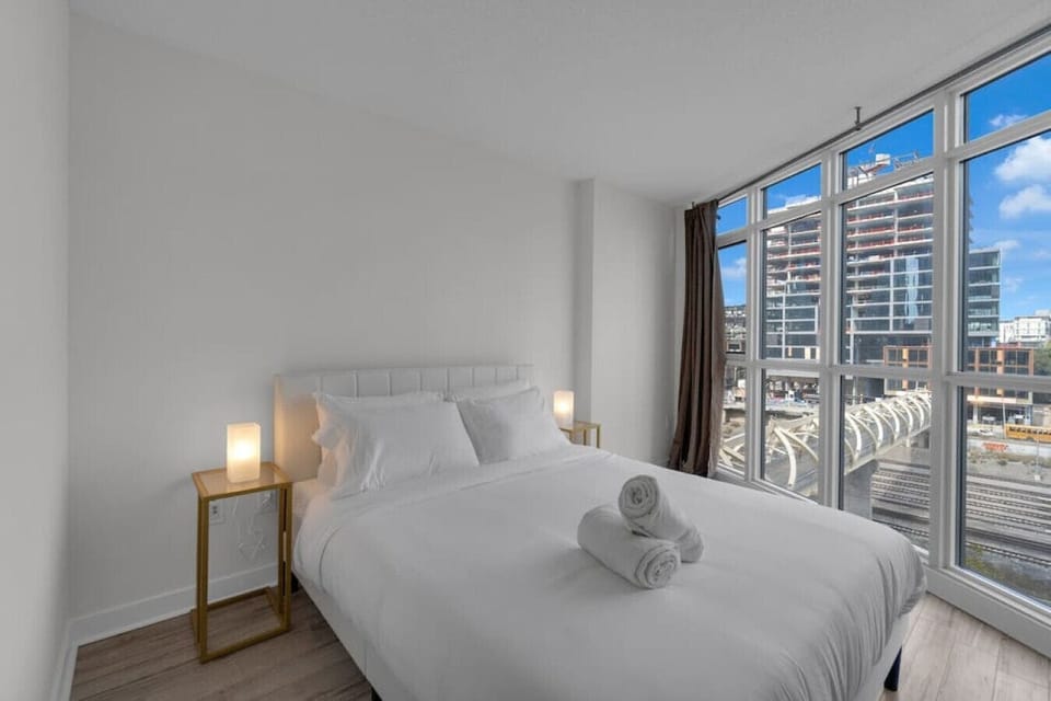 Spacious bedroom with queen size bed and a view - floor to ceiling windows bring in tons of light, but don't worry - we have room darkening shades should you want to sleep in.