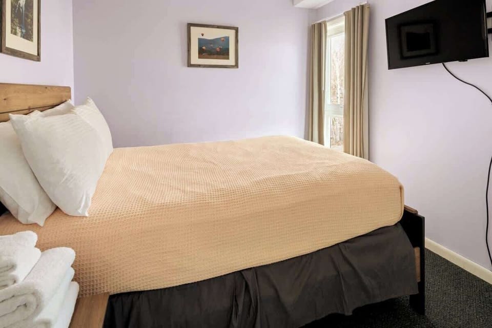 Unwind in this inviting bedroom featuring a full bed and a private ensuite with a refreshing shower, the perfect combination for a restful escape