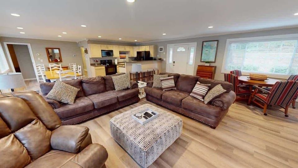 Relax and unwind in this spacious living room with brown sofas and an armchair.