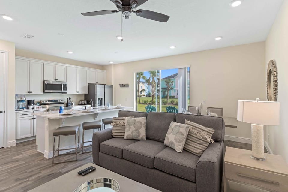 Elegant living area of the cottage in Kissimmee Florida - Modern elegance meets cozy comfort - Explore the perfect fusion of kitchen and living area - Easy access to outdoors with seating