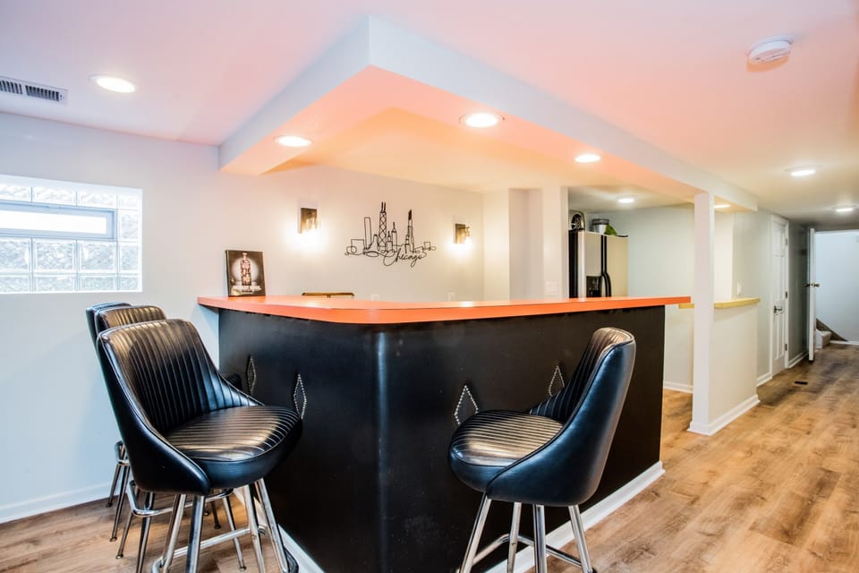 The bar features a full fridge, sink and plenty of cabinet and shelf space
