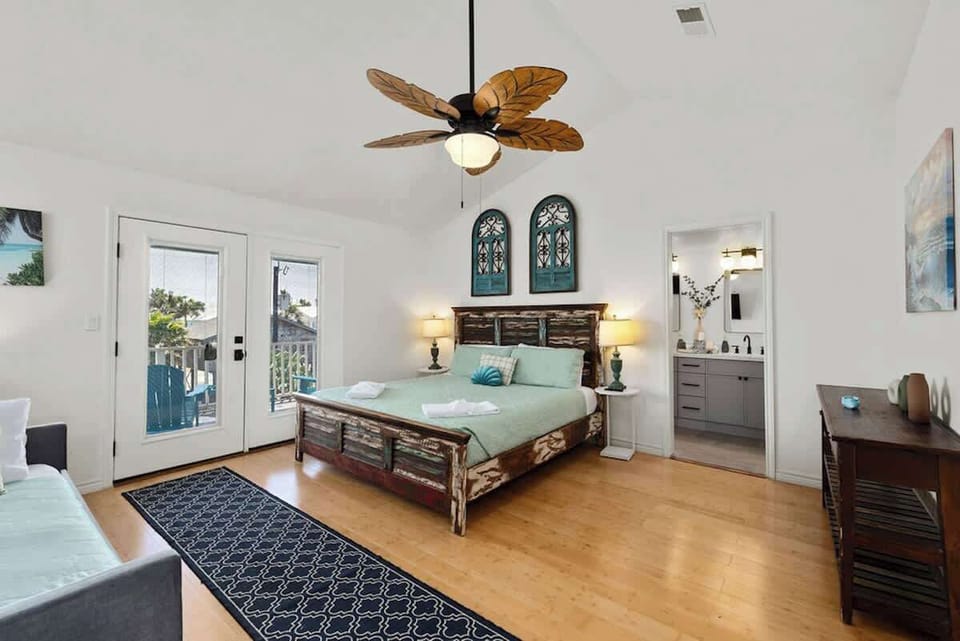 Primary suite features a king bed, twin day bed with trundle, private balcony, air conditioning, and a newly renovated ensuite bathroom for added comfort and privacy.