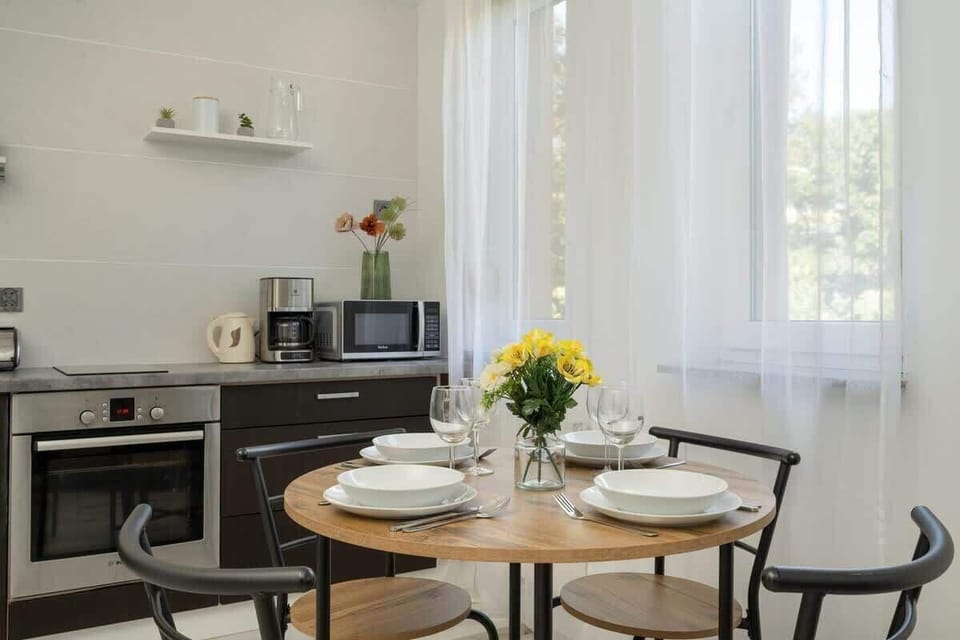 A compact kitchen with dark cabinets, open shelving, and stainless steel appliances, offering a modern and functional cooking space.

