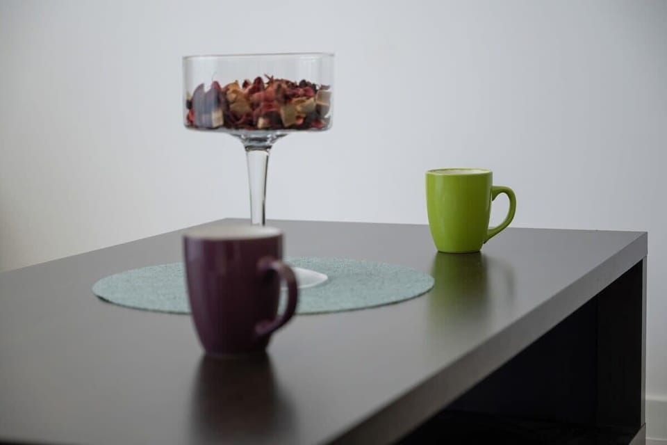 A close-up of a side table with colorful coffee mugs and a glass centerpiece, adding charm to the living space.
