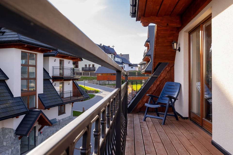 A wooden balcony with outdoor seating, providing a relaxing spot with views of the charming neighborhood.
