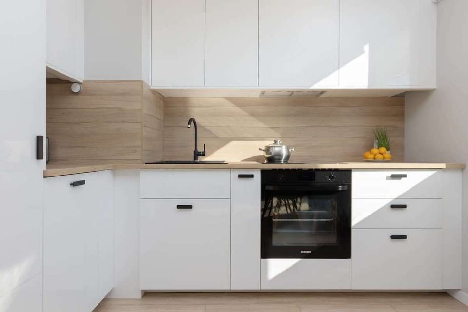 Another angle of the kitchen highlighting its modern white cabinetry, built-in appliances, and clean design.
