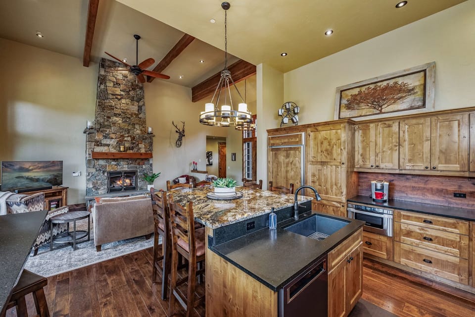 Luxury meets functionality in this mountain home's main dining area, featuring granite countertops and a spacious center island that serves as the perfect gathering spot for family and friends