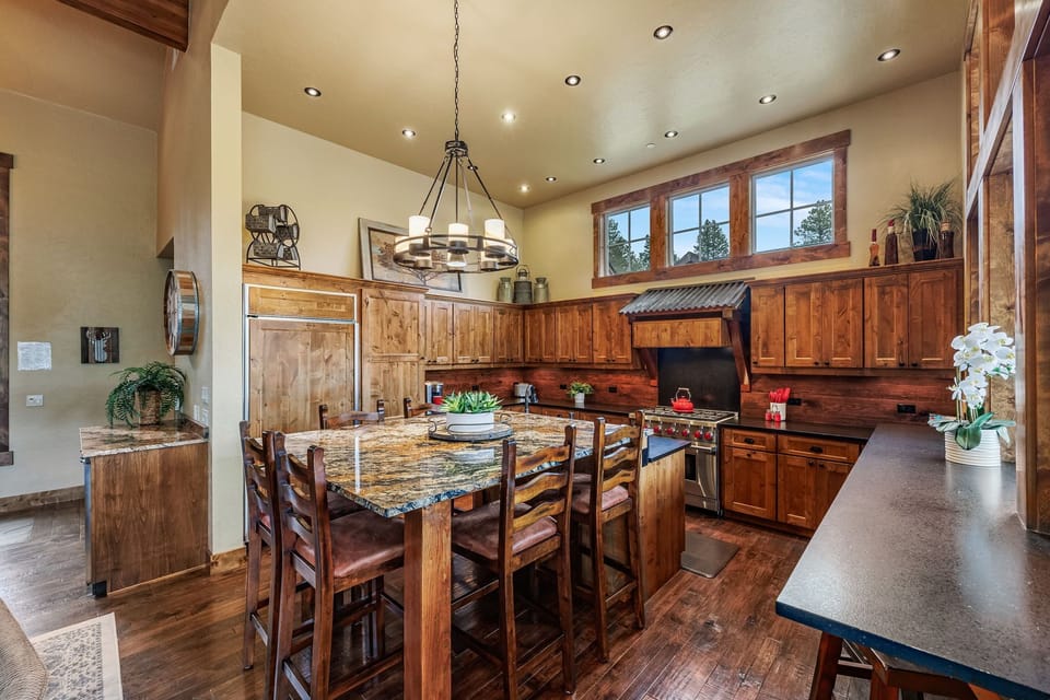 Luxury meets functionality in this mountain home's main dining area, featuring granite countertops and a spacious center island that serves as the perfect gathering spot for family and friends