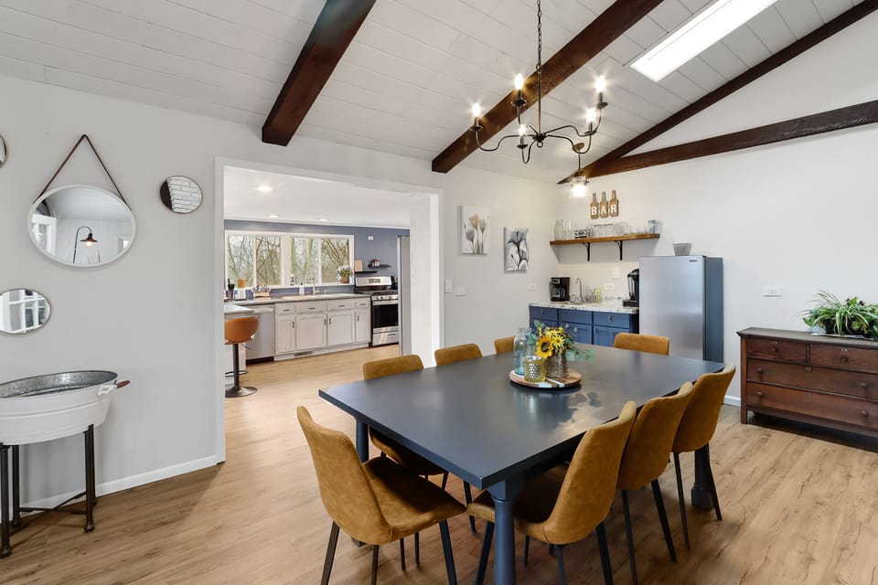 Centrally located dining/gathering area with wet bar and beverage refrigerator. 